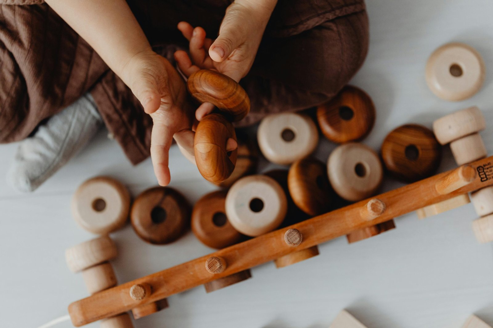 A child enjoying hands-on fun with wooden toys, promoting learning and development.