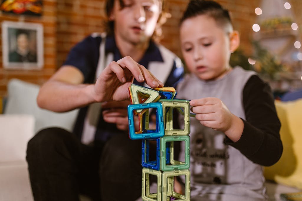 A father and son enjoying quality time building a tower with colorful magnetic blocks.