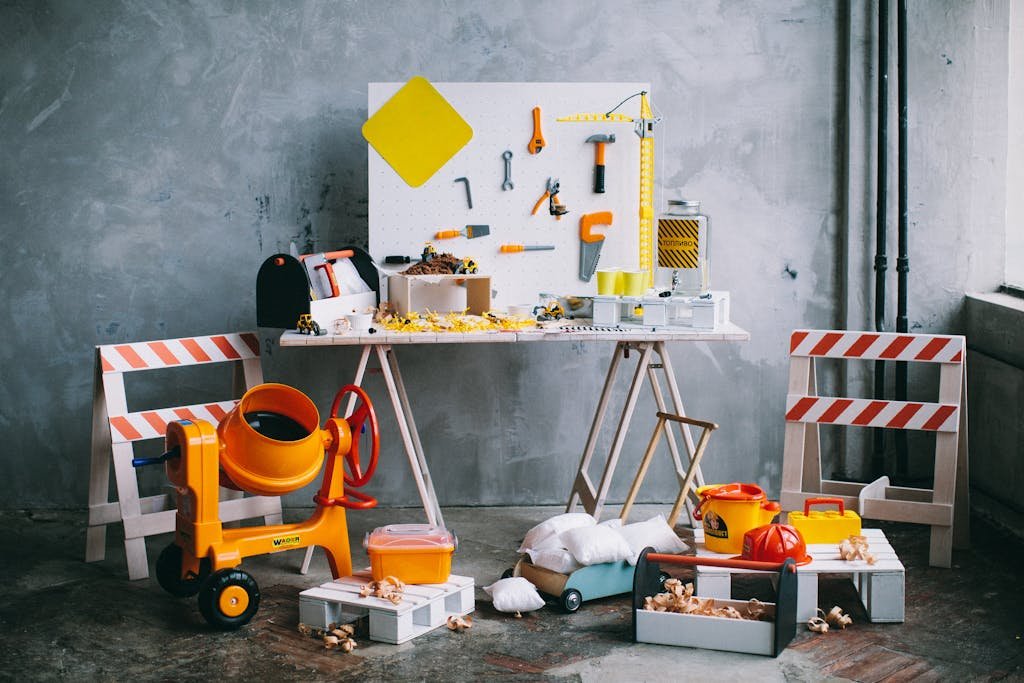 A playful arrangement of mini toy construction tools and accessories on a table indoors.