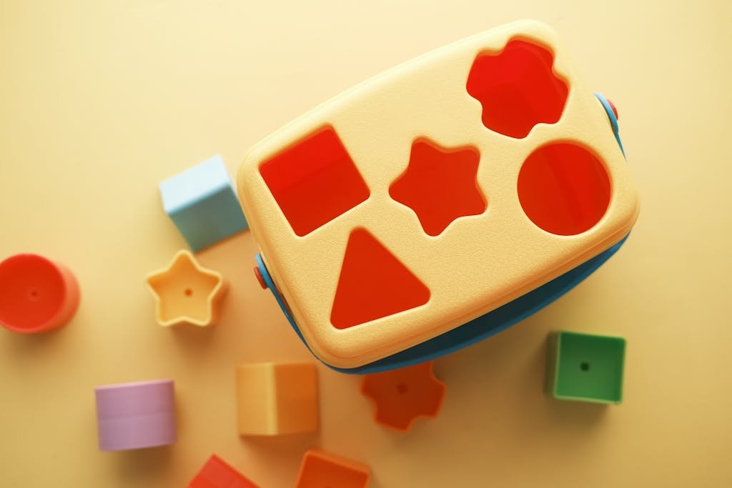 A vibrant shape sorter toy with various blocks on a yellow background, perfect for early childhood education.