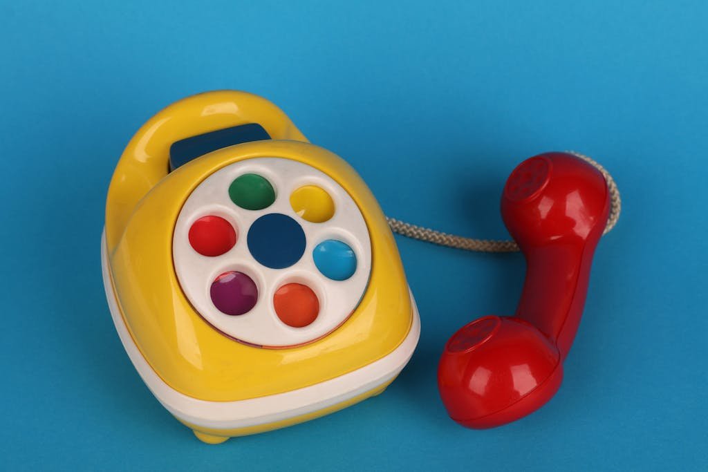 Brightly colored vintage toy telephone on a blue background, showcasing its vibrant design.