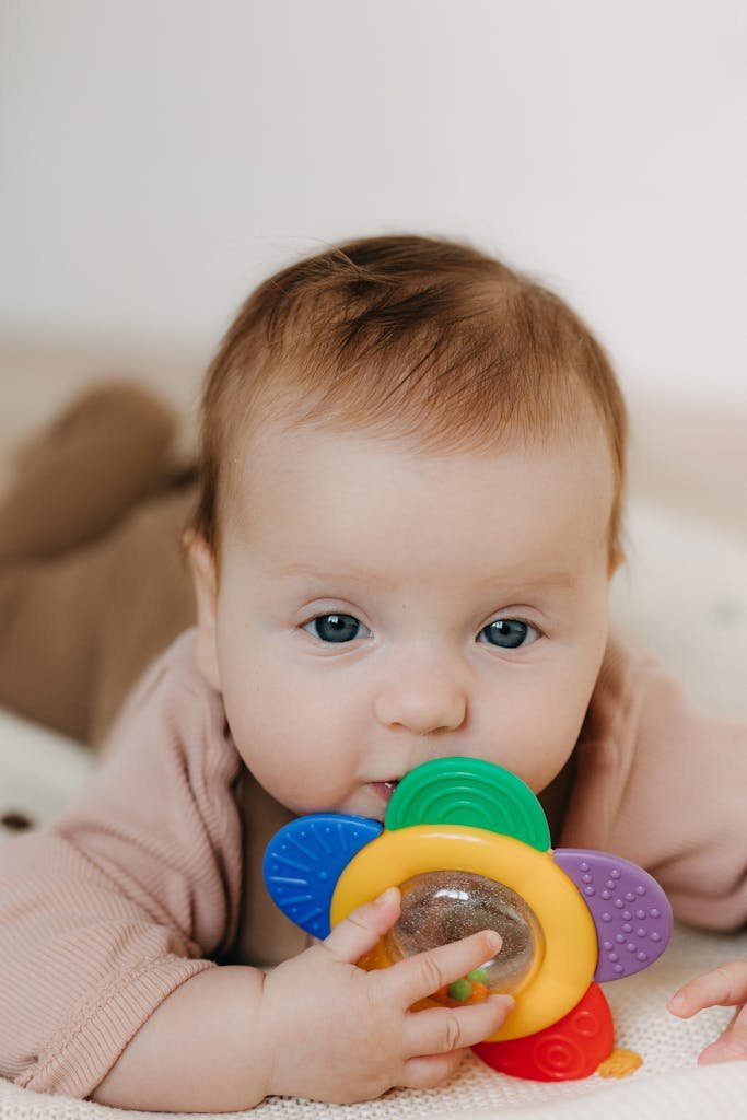 Cute baby playing with a colorful teething toy, perfect for parenting and lifestyle themes.