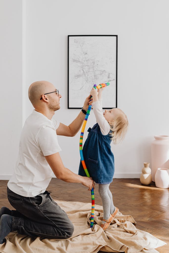 Father engaging with daughter in creative play, building a tower with colorful blocks.