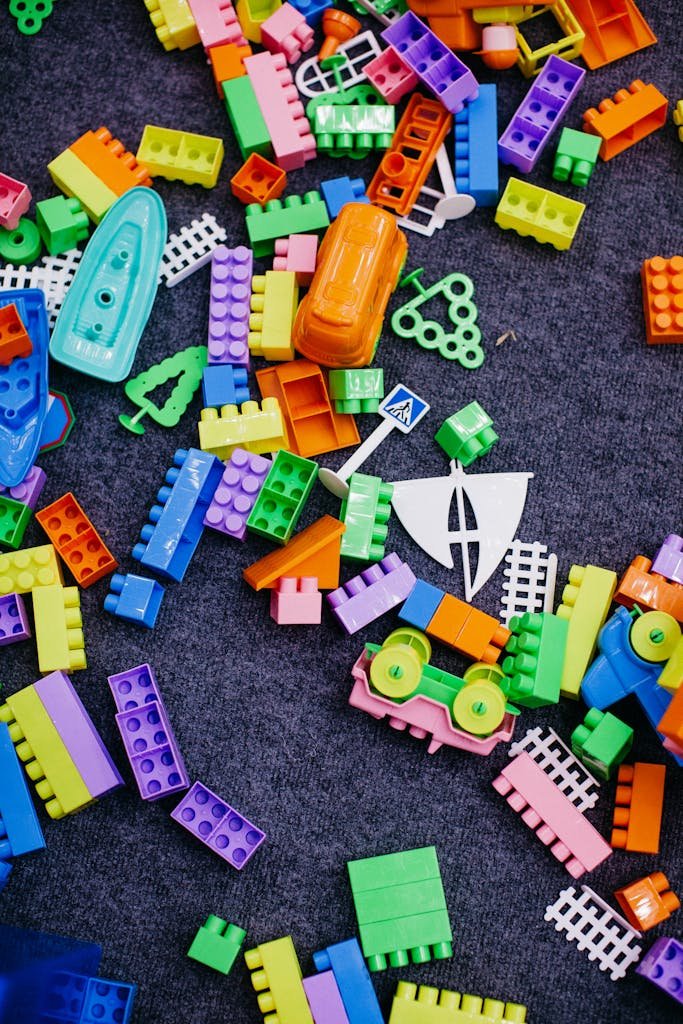 Vibrant assortment of plastic building blocks spread across a carpet, showcasing creative play.