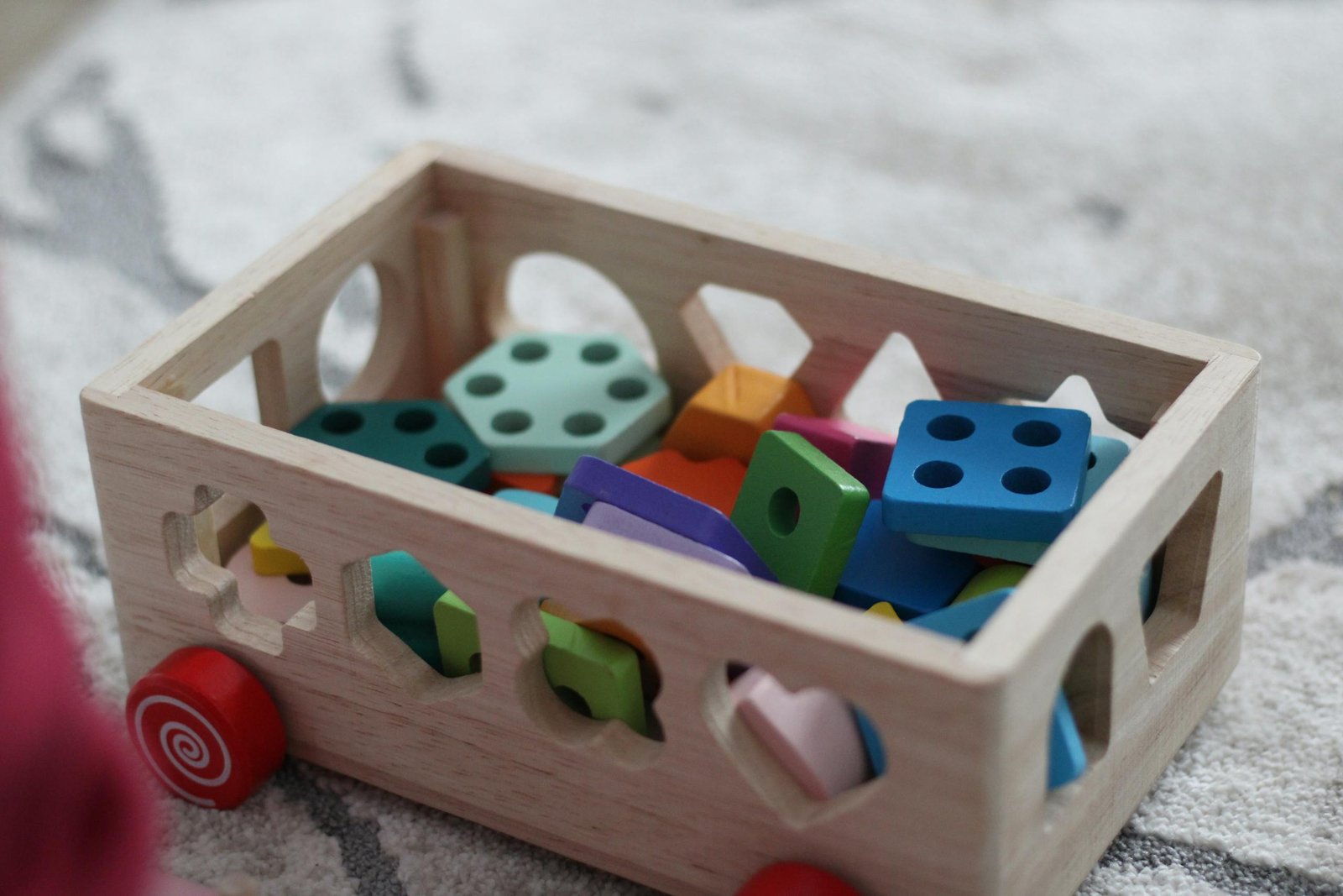 Vibrant wooden educational toys in a box, perfect for young children's playtime.